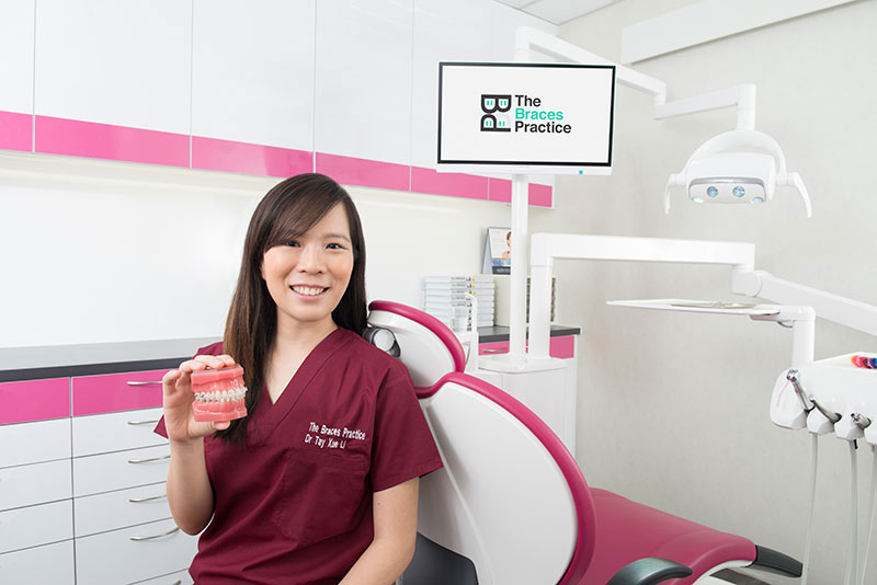 Dr Tay Xue Li Holding Dental Teeth Model